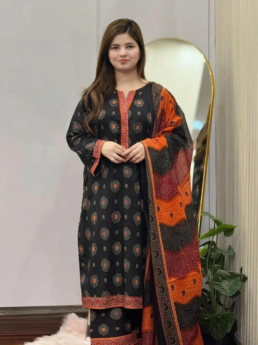 Woman wearing a black and orange patterned dress with a matching shawl indoors.