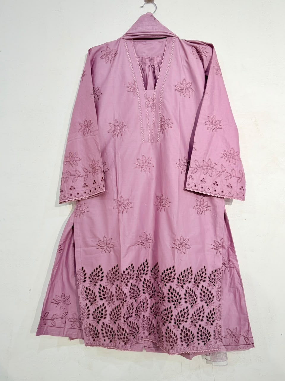 Pink embroidered traditional outfit on a white background