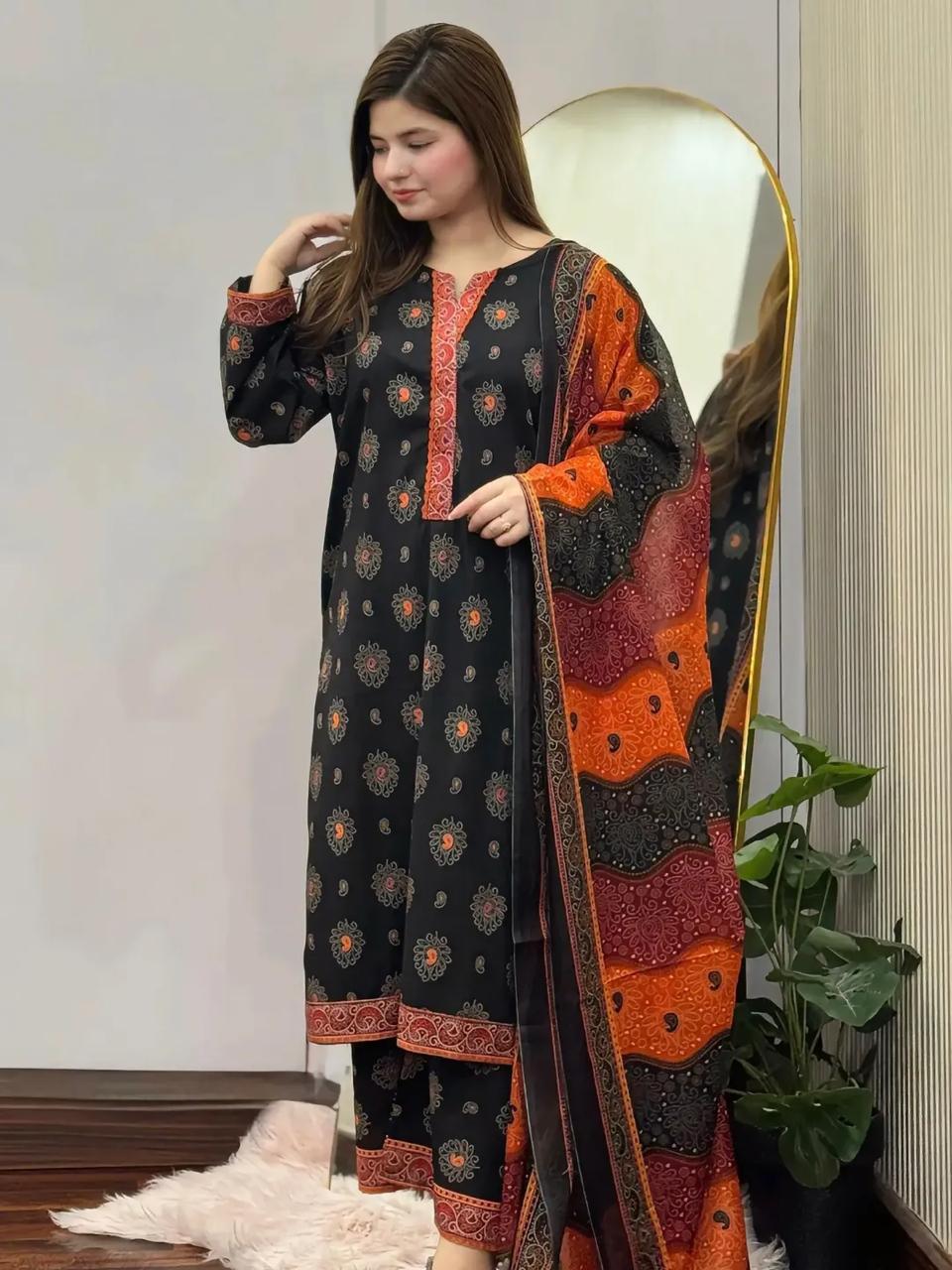 Woman wearing a black and orange traditional outfit with a patterned shawl.