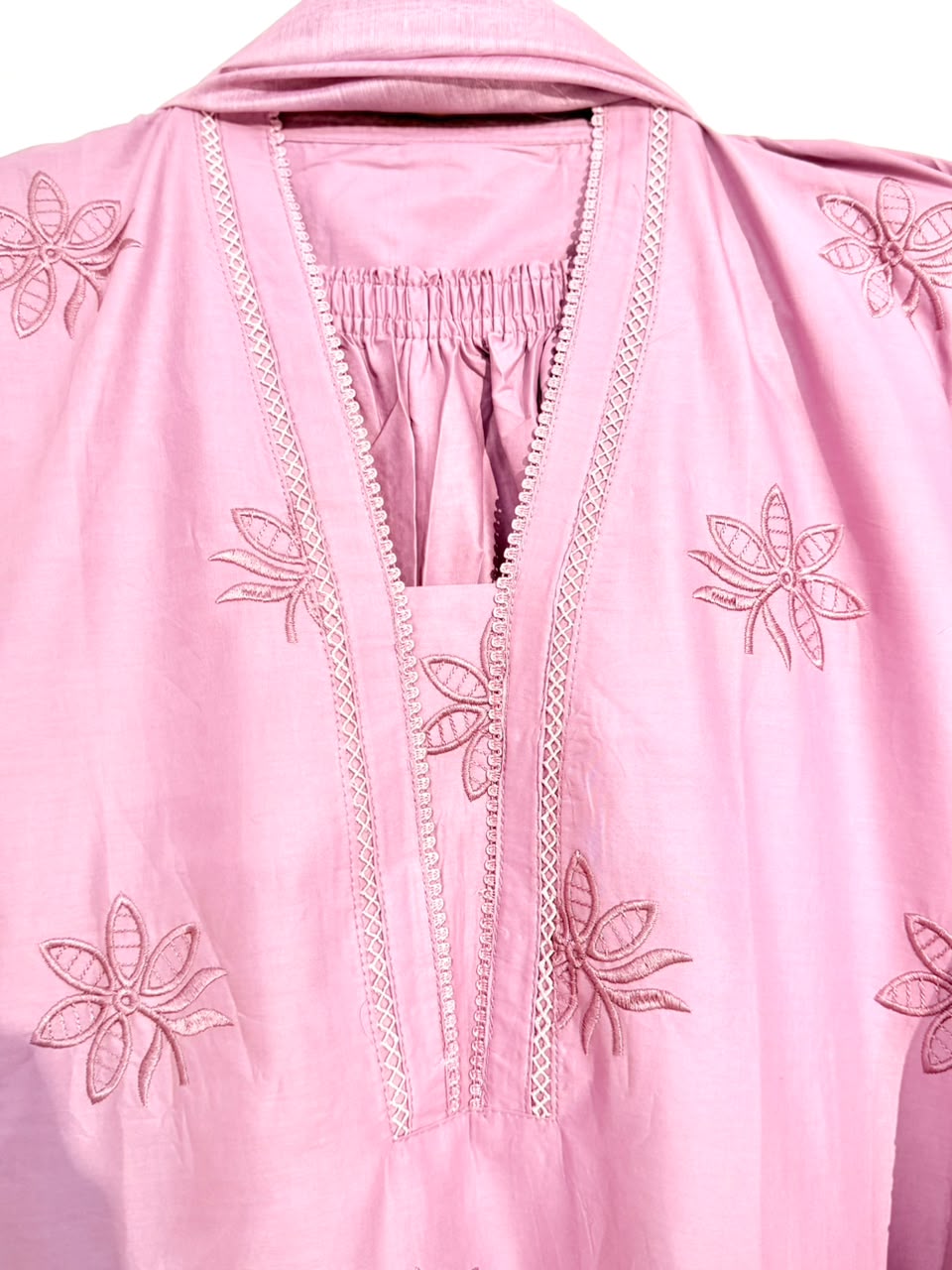 Pink garment with floral embroidery on a white background