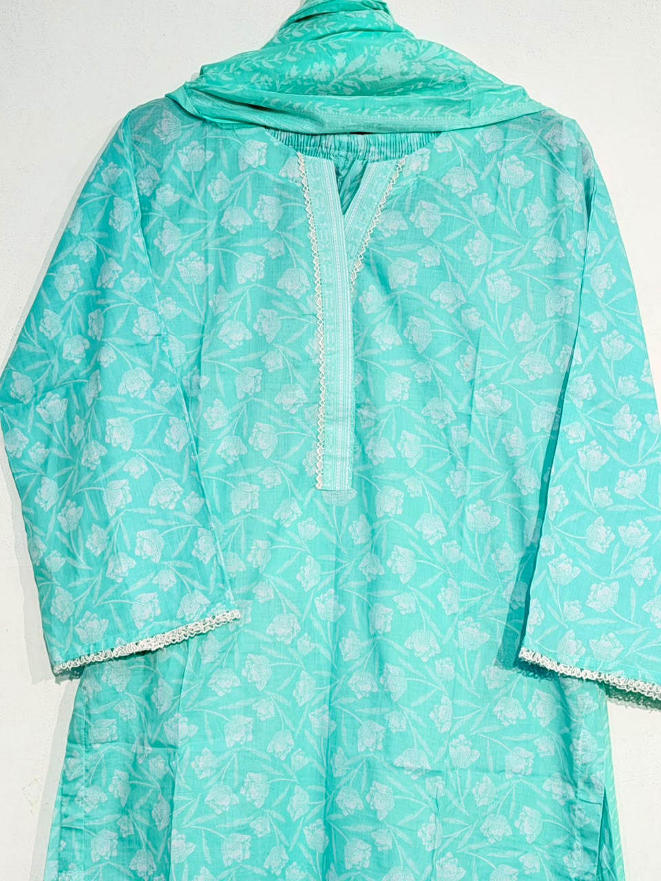 Mint green floral print close-up with lace neckline