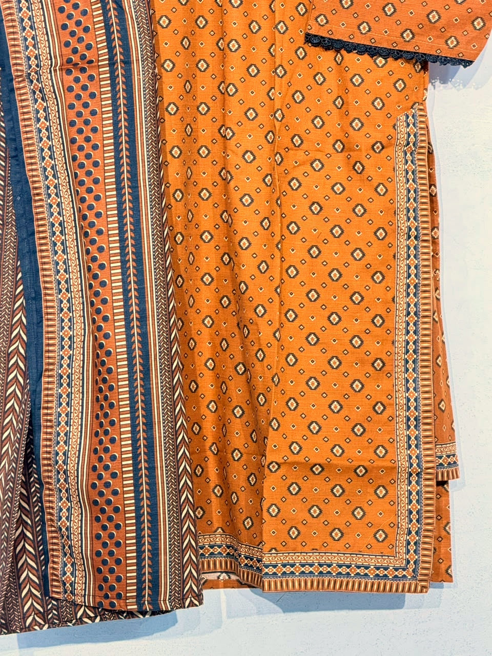 Polished close-up of mustard fabric print, navy dupatta and border