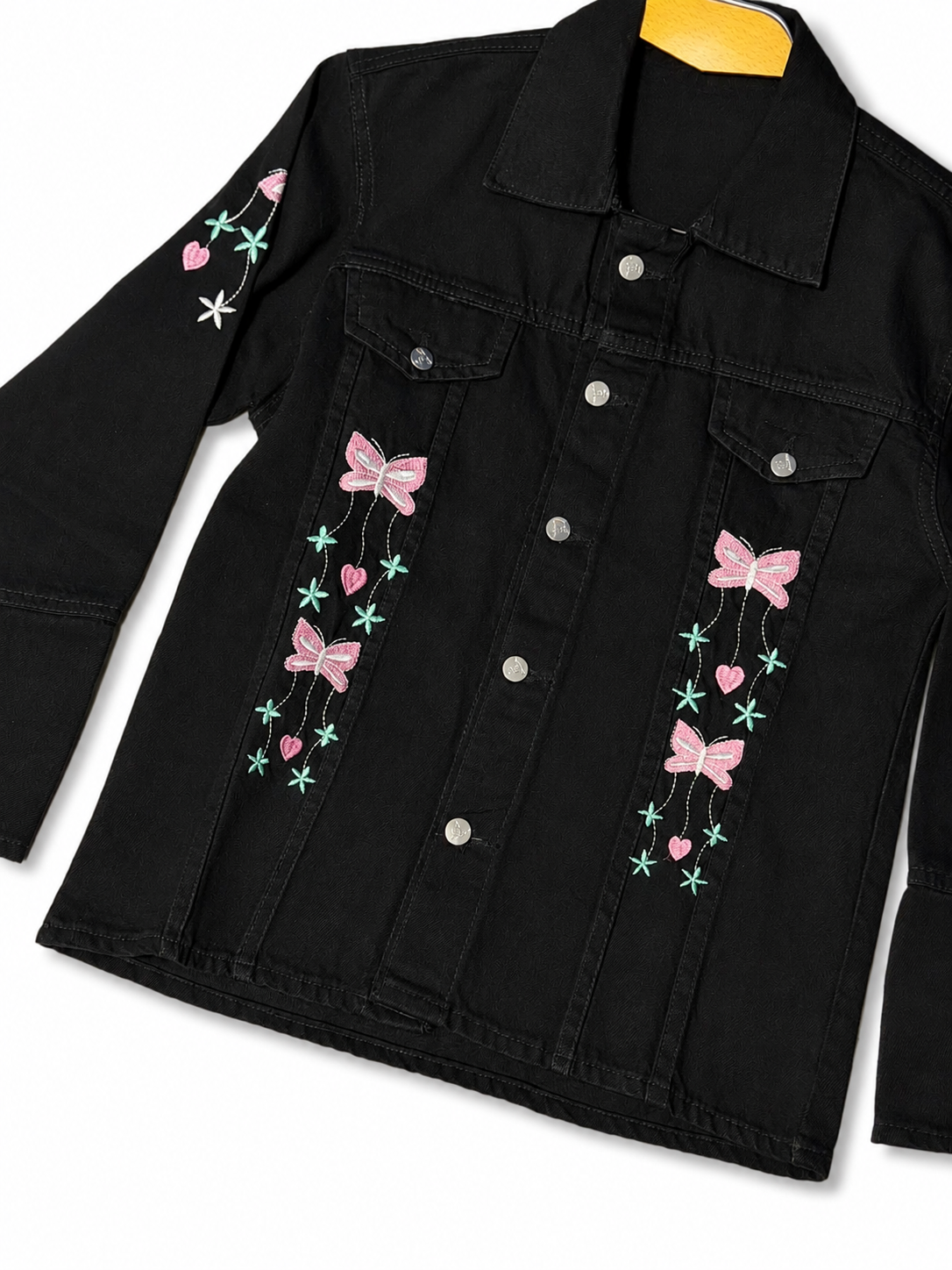 Women's black denim jacket with pink bow embroidery – angled view