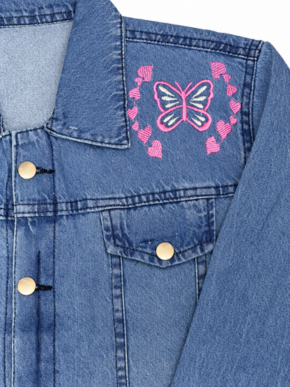 Pink butterfly and heart embroidery detail on women's blue denim jacket
